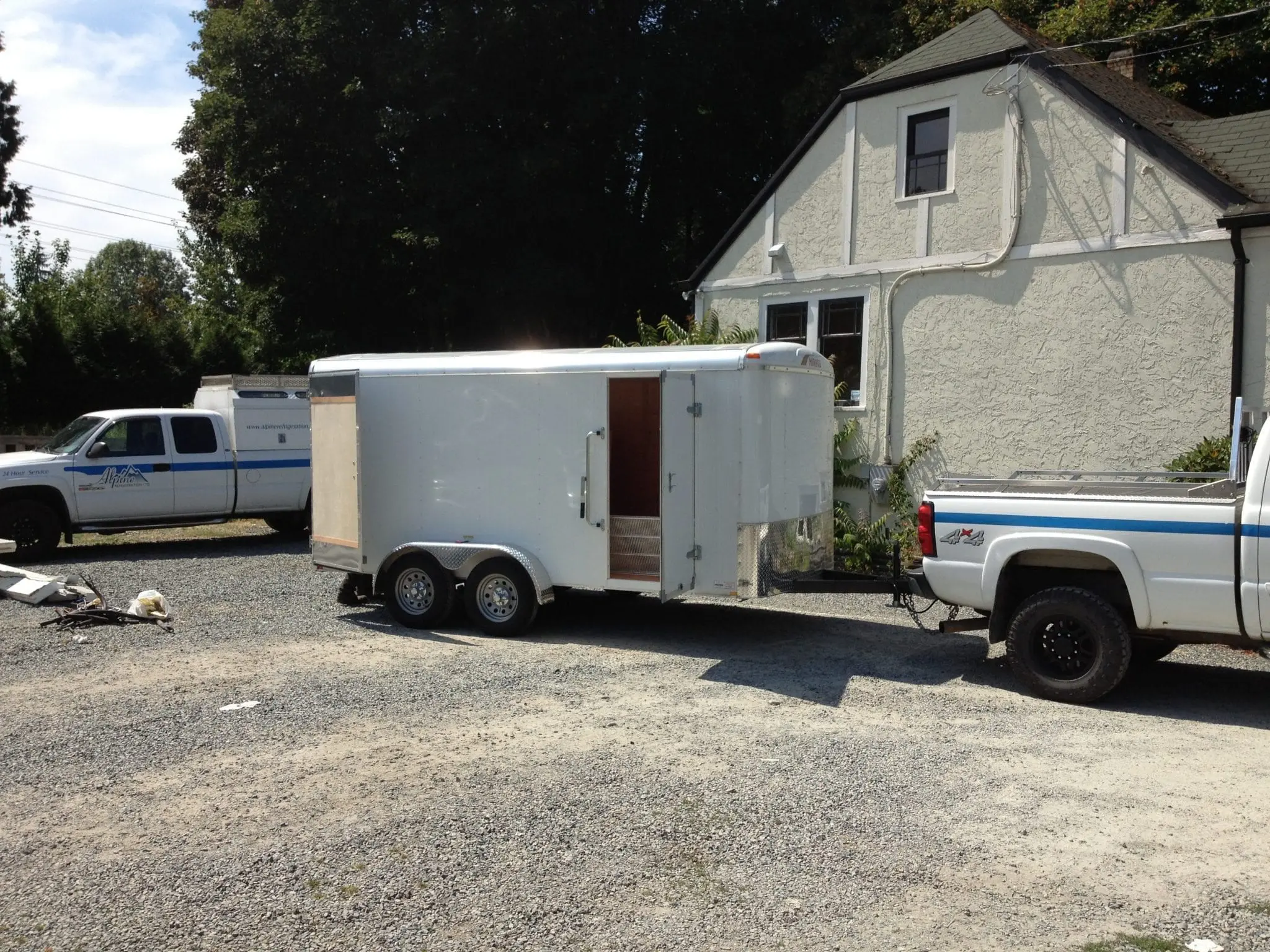 Service Fleet with Equipment Trailer Alpine Refrigeration equipment trailer and service trucks at job site